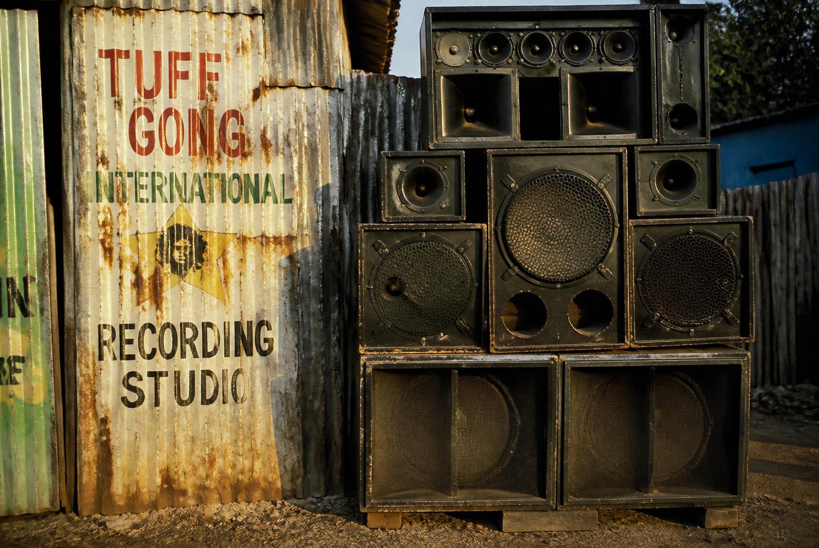Hand-built sound system speaker boxes stacked beside a hand-painted zinc wall